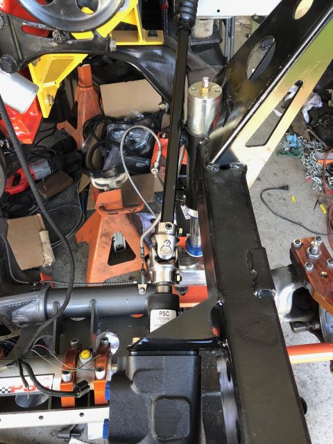 1992 Jeep Wrangler - A close-up view of the steering column and steering box assembly of a vehicle, likely a Jeep Wrangler, under construction. The black metal…