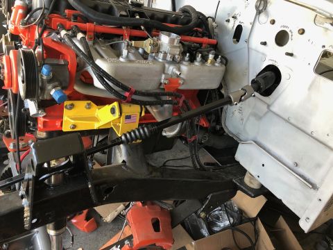 1992 Jeep Wrangler - A close-up view of a vehicle's engine bay during a build, showing the engine, steering column, and parts of the chassis. The engine is pred…