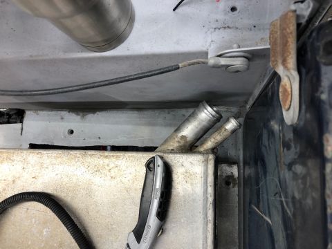 1992 Jeep Wrangler - A close-up view shows two metal tubes protruding from a rectangular metal tank, likely part of a vehicle's fluid system. A utility knife an…