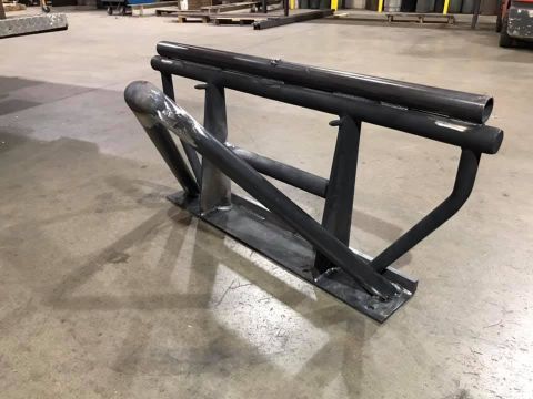 1992 Jeep Wrangler - A custom fabricated metal rack with a flat base plate and multiple tubular supports is shown on a concrete floor.