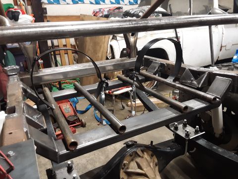 1985 Toyota Hilux - The underside of a vehicle frame is shown, with custom metal fabrication and suspension components being installed. A rear differential and…