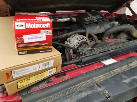 1997 Ford F-250 - Engine parts are shown in their packaging, with some mechanical components visible in the background.