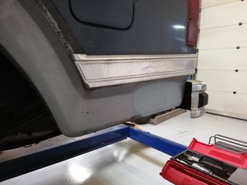 1996 Ford Bronco - The rear side of a Ford Bronco is shown on a lift, with a toolbox nearby.