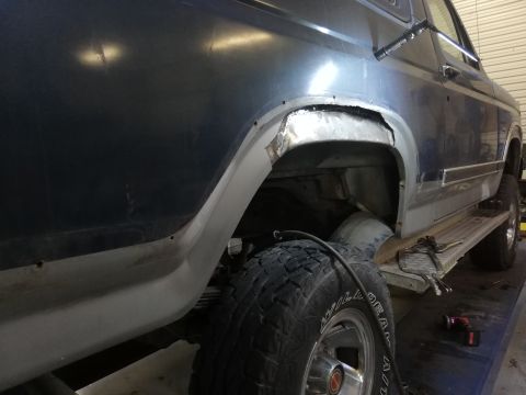 1996 Ford Bronco - This SUV shows significant body damage around the rear wheel well, indicating repair work is in progress.