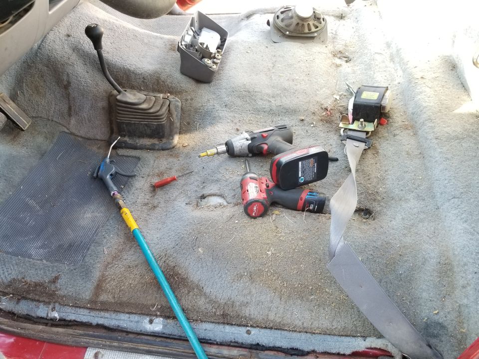 Because the cab was as filthy as the undercarriage, and because the seat was broken, and because the headliner was sagging, I pulled out all the upholstery.  Many of the screw heads required scraping out before the bit could engage. The t-case shifter bezel is the worst because the screw wells are so deep, and they're not capped.  Shop air helps.
IF THE IMAGE IS TOO SMALL, click it.