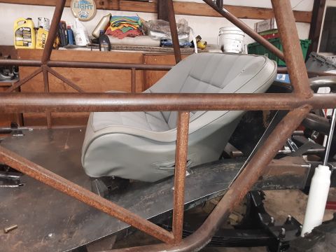 1985 Toyota Hilux - Interior view of a custom vehicle, a grey bucket seat surrounded by a metal roll cage structure.