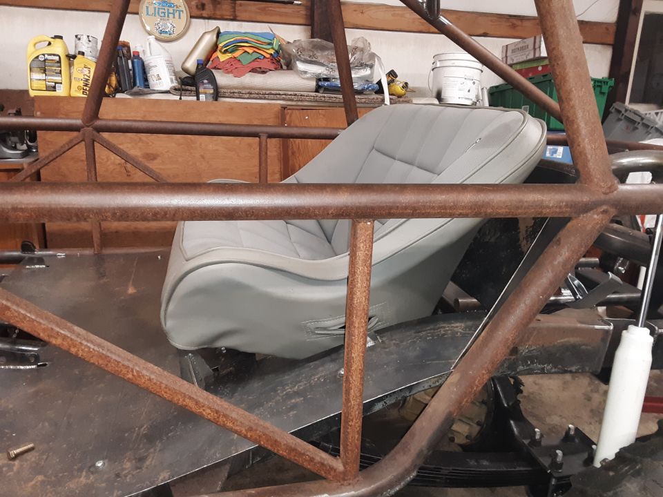 Grey bucket seat inside a custom vehicle with a roll cage
