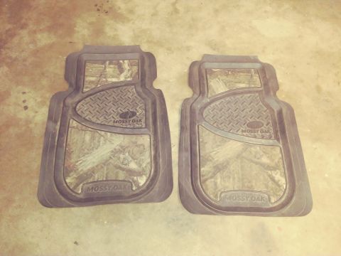 1996 Ford Bronco - A pair of Mossy Oak branded floor mats are displayed on a concrete surface.