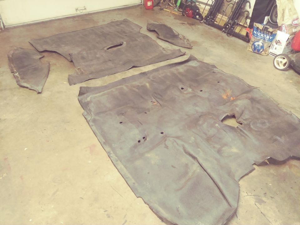 Car floor mats laid out on a concrete floor