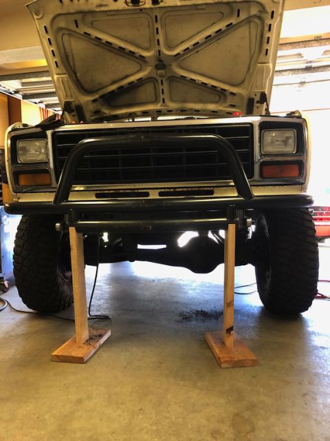 1981 Ford Bronco - The front of a Ford Bronco is shown with its hood open and a bull bar attached to the bumper, supported by wooden blocks.