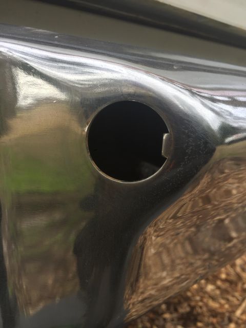 1979 Ford Bronco - A close-up view of a chrome bumper shows a circular cutout, reflecting the surroundings.