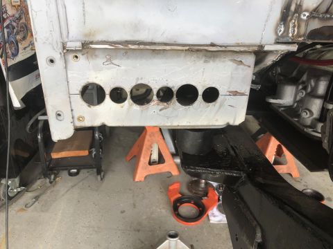 1992 Jeep Wrangler - Underside of a vehicle frame, showing a section with several holes and being worked on.