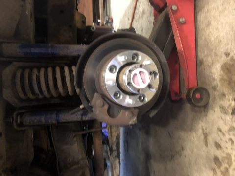 1979 Ford Bronco - Close-up view of a vehicle's wheel hub assembly, showing a spacer and a pink locking mechanism.