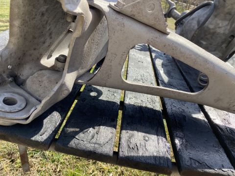 1994 Ford Bronco - A close-up view of a metal suspension part, likely from a vehicle, is shown outdoors.