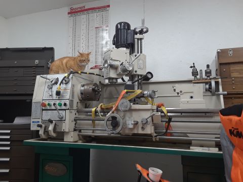 1994 Ford Bronco - An orange tabby cat rests atop a metal lathe in a workshop setting.