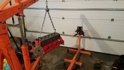 1985 Ford Bronco - Engine block is being lifted by an engine hoist in a garage.
