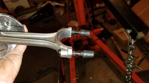 1985 Ford Bronco - A close-up view of an engine connecting rod with its cap bolts visible.