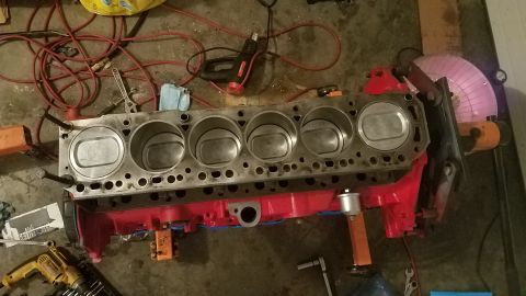 1985 Ford Bronco - Engine block with pistons and red oil pan, surrounded by tools and electrical cords.