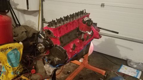 1985 Ford Bronco - A red V8 engine is mounted on an engine stand, ready for installation or further work.
