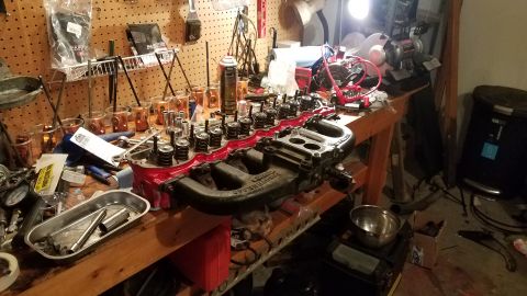 1985 Ford Bronco - Engine parts laid out on a workbench for repair or assembly.