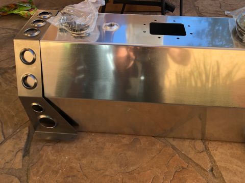 1992 Jeep Wrangler - A polished metal fuel tank with multiple circular cutouts is shown on a stone patio. The tank has a rectangular opening on its top surface…