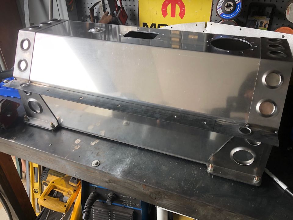 Custom metal fabricated box with circular cutouts on a workbench.