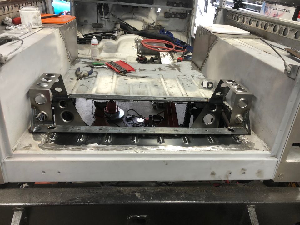 Custom metal fabrication in the floor of a vehicle under construction.
