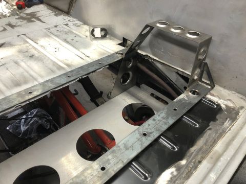 1992 Jeep Wrangler - A custom metal fabrication is being installed inside a vehicle, likely for a roll cage or battery box. The fabrication features several cir…