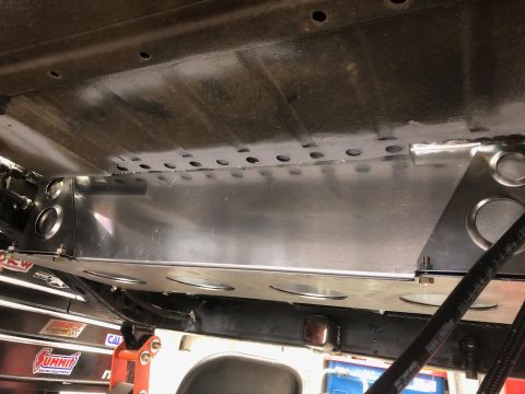 1992 Jeep Wrangler - Underside view of a vehicle showing a custom aluminum skid plate installed with numerous bolts and rivets. The skid plate features circular…