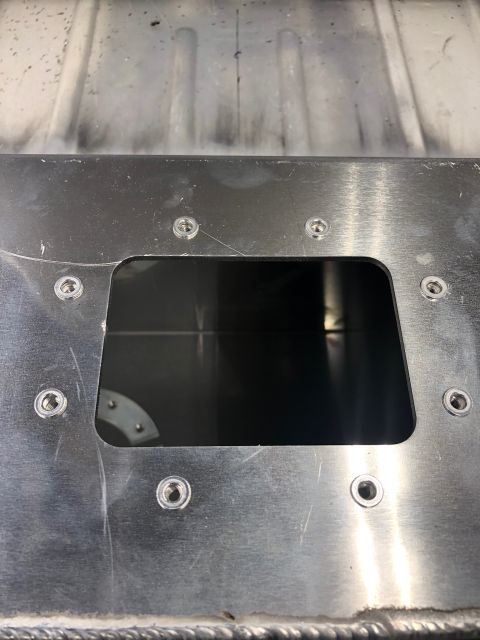 1992 Jeep Wrangler - A close-up view shows a rectangular cutout in a brushed aluminum panel, surrounded by several silver screws. The cutout reveals a dark inte…