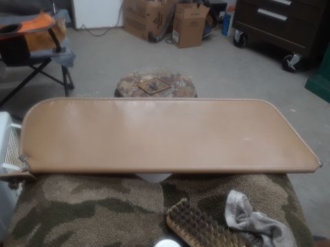 1994 Ford Bronco - A tan sun visor is laid out on a camouflage patterned cloth. A brush and a gray rag are visible in the foreground.
