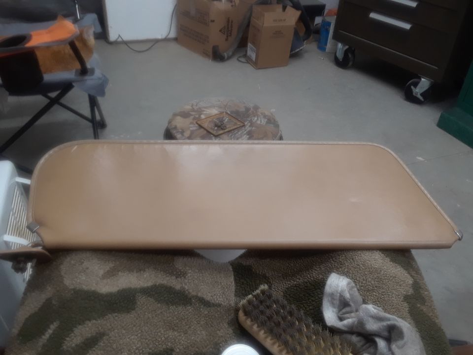 Tan sun visor on camouflage cloth with brush and rag
