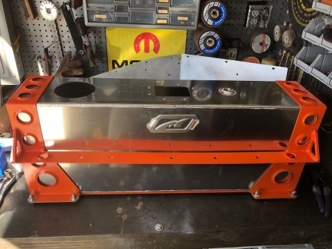 1992 Jeep Wrangler - A custom-built aluminum fuel tank with orange powder-coated end caps and support brackets is shown on a workbench. The tank features a prom…