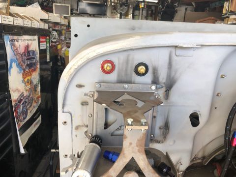 1992 Jeep Wrangler - A close-up view of the firewall area of a vehicle build, showing newly welded metal, electrical terminals, and custom brackets.