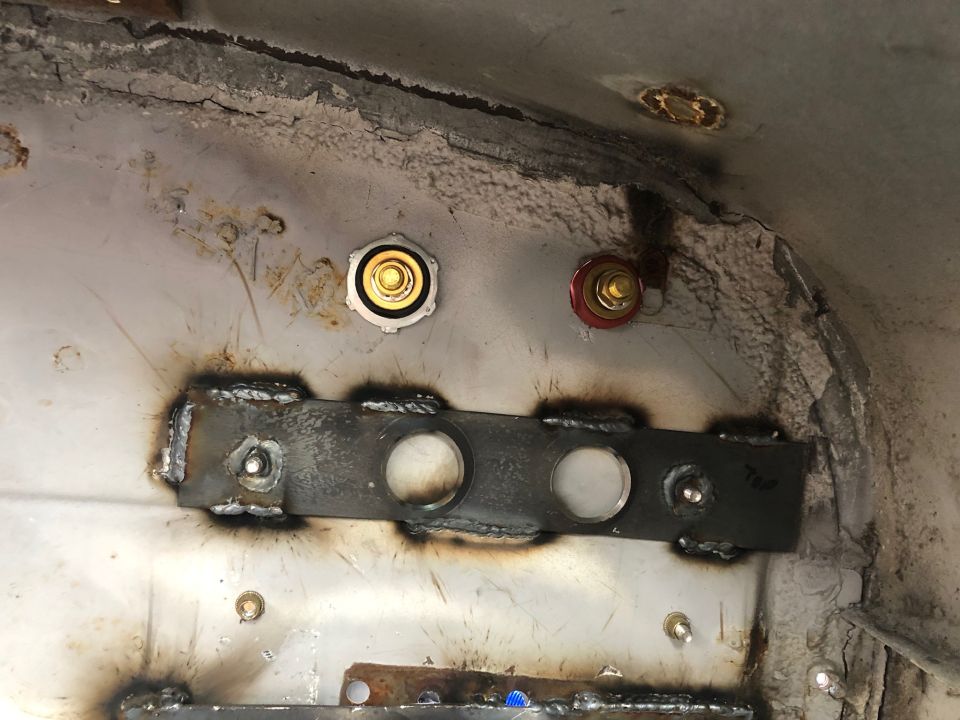 Close-up of welded bracket and fasteners on vehicle undercarriage