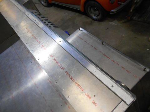 1992 Ford Bronco - Two pieces of aluminum sheeting with red text stamped on them are laid out on a floor. The sheeting appears to be part of a vehicle build o…
