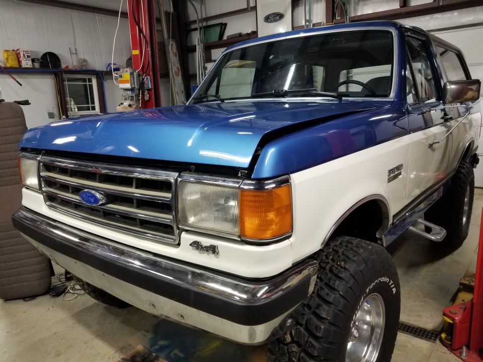 1991 Ford Bronco with blue and white paint, lifted with large tires