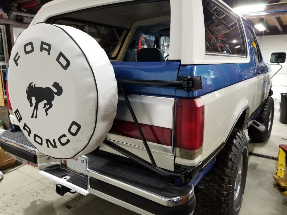 White spare tire cover with black Ford Bronco logo and lettering