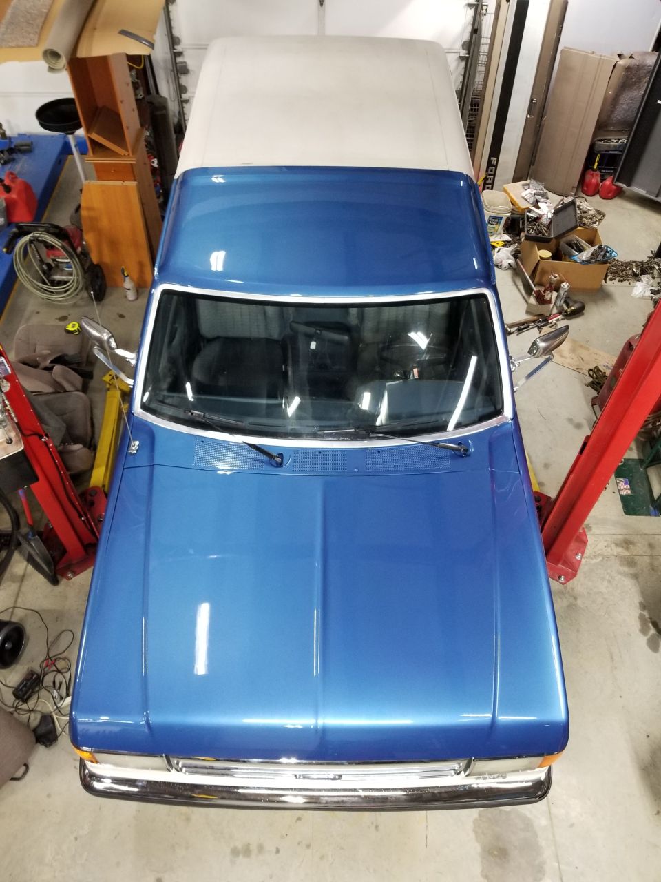 Top-down view of a blue 1980s Ford F-Series pickup truck with a white camper shell