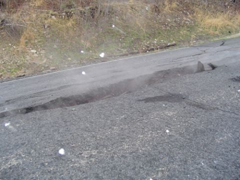 1979 Ford Bronco - Roadway damage is visible, with a significant portion of the asphalt collapsed.