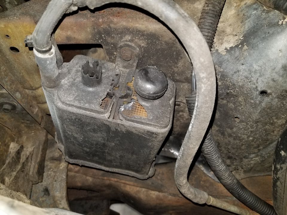 Engine component with hoses attached, showing wear and damage