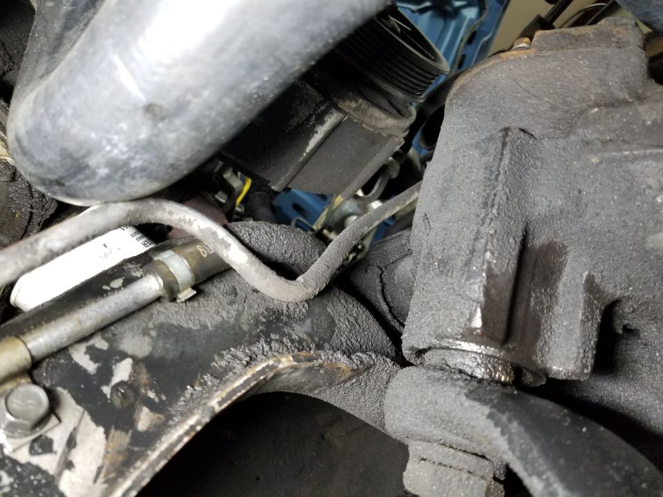 There's a fluid leak from the return hose at the cooler, but not much from the pump itself.  The shiny splines on the steering box sector shaft indicate how loose the pitman arm is, due to the nut being backed off so much that the split washer isn't flat.