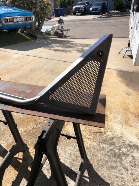 1992 Jeep Wrangler - A custom metal fabrication, possibly a roll cage or bumper component, is shown resting on sawhorses. The part is triangular with a perforat…