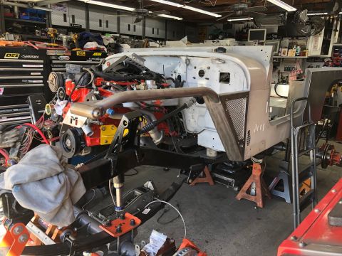 1992 Jeep Wrangler - A partially assembled Jeep Wrangler chassis with the engine installed is shown in a garage setting. The vehicle is elevated on jack stands…