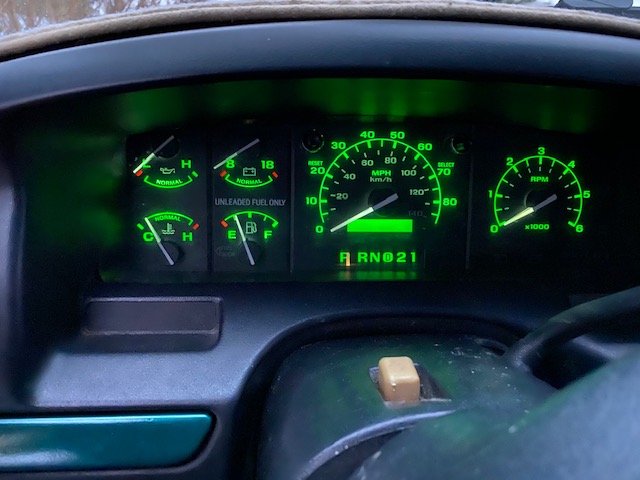 1996 Ford Bronco dashboard gauges illuminated in green.