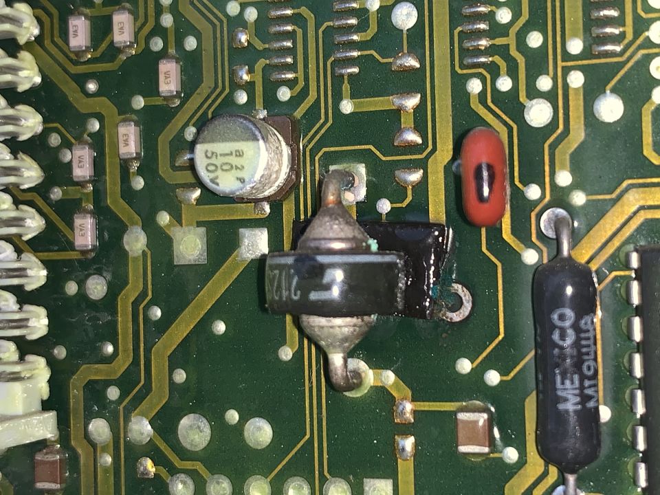 Close-up of a circuit board showing capacitors, resistors, and a diode with markings '2128' and 'MEXICO MTQULLA'