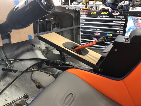 1992 Jeep Wrangler - Interior view of a custom vehicle build, showing a steering column, a floor-mounted shifter with orange levers, and custom upholstered seat…