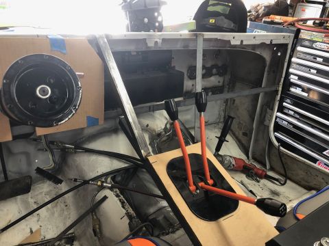 1992 Jeep Wrangler - The interior of a vehicle under construction shows a custom dashboard with a large circular component mounted on cardboard. A central conso…