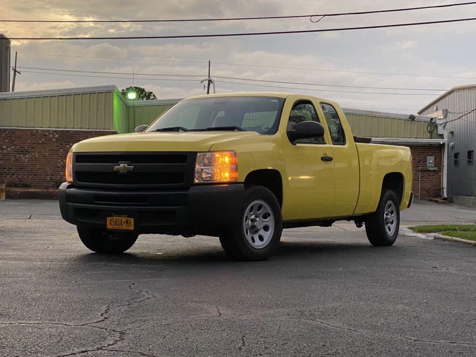 Yellow 2011 Chevrolet Silverado 1500 pickup truck, front 3/4 view.