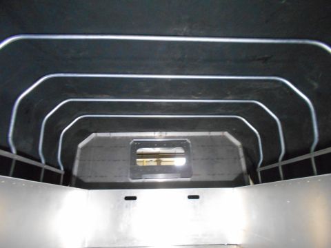 1992 Ford Bronco - Interior view of a vehicle's cargo area, showing metal walls and a dark ceiling with parallel metal support bars. A rectangular window is v…